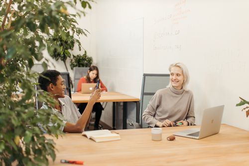 Free Three colleagues having a casual meeting in a bright, modern office space. Stock Photo