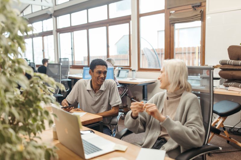 Diverse team collaborating in a creative office setting, showcasing teamwork and smiling expressions.