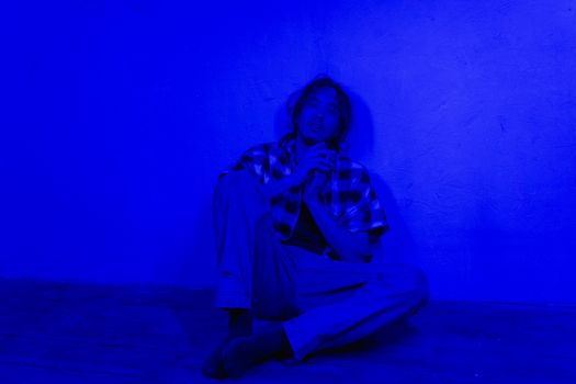 A Man in Plaid Shirt Sitting on the Floor