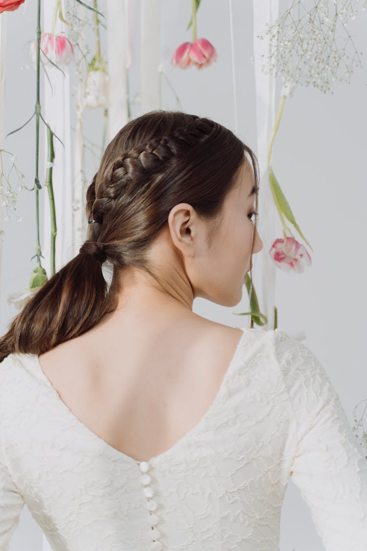 Back View Of A Woman With Brown Braided Hair Wearing A Wedding Dress 