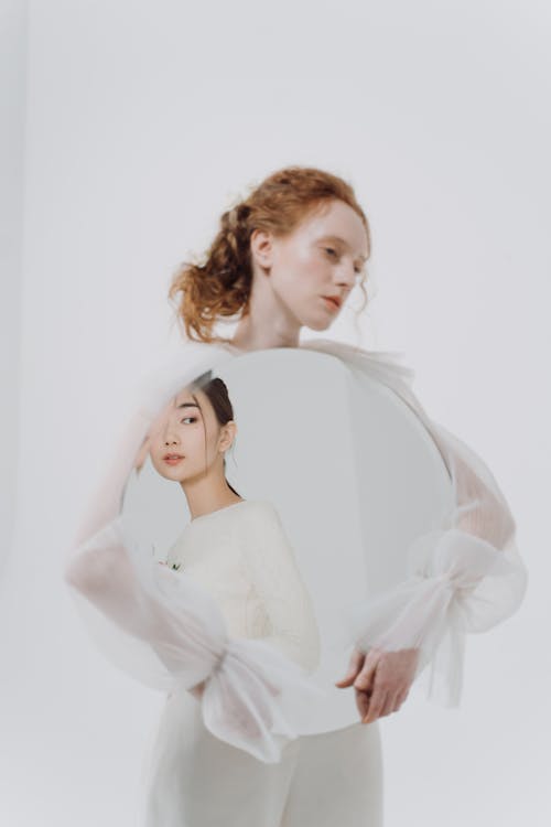 A Woman Holding a Big Round Mirror