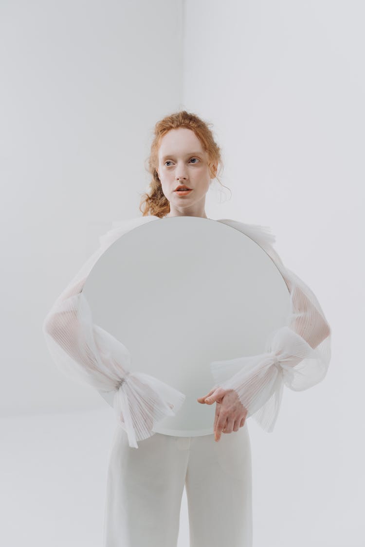 A Woman Holding A Big Round Mirror