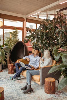 Casual business discussion between colleagues in a cozy indoor office environment.