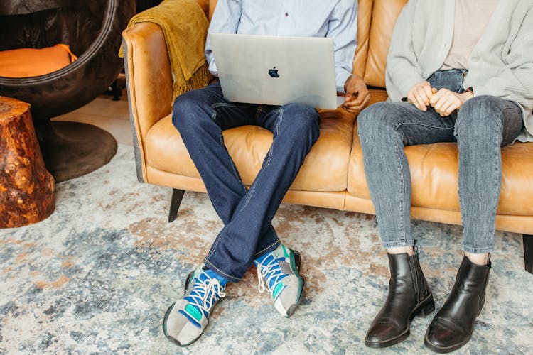 Two People Sitting On Brown Leather Couch