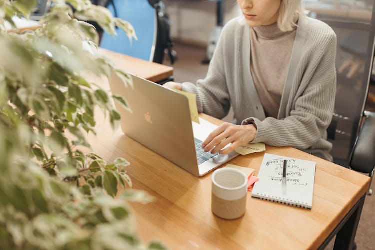 Woman Sitting In Front Of Silver Laptop