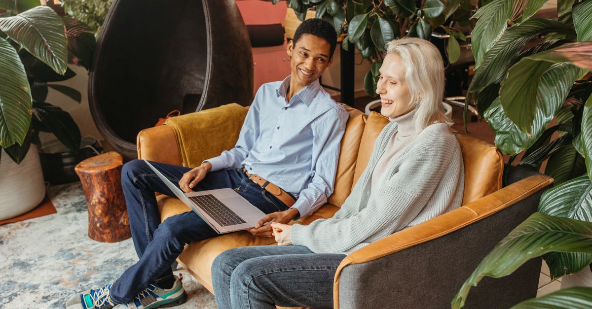 A diverse group of micro-business owners collaborating and laughing in a bright, modern co-working space