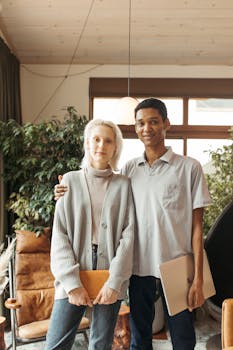 A diverse duo posing confidently in a stylish office environment.