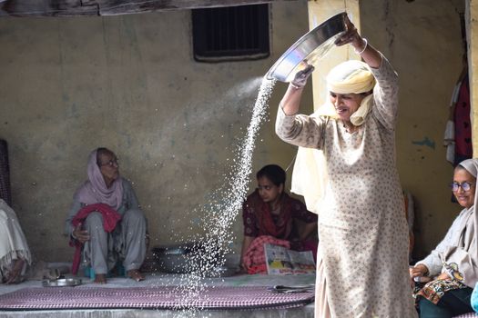 A Woman in White Dress Cleaning Grains