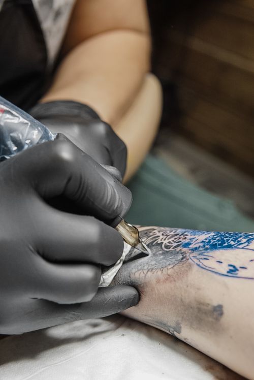 Free Detailed close-up of a tattoo artist creating an intricate design on a forearm with precision. Stock Photo