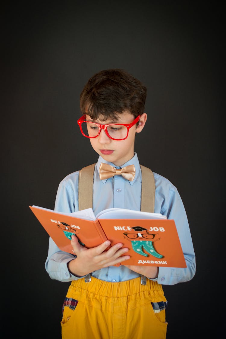 Little Boy In Glasses Reading Book