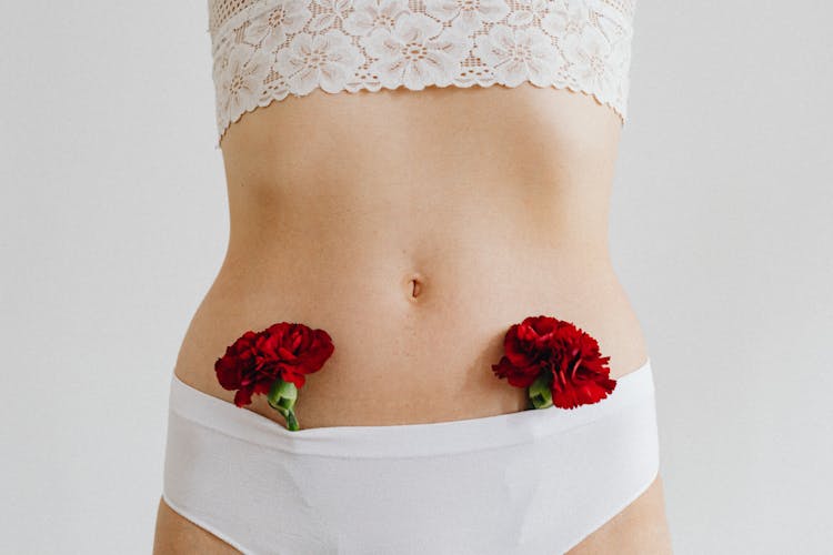 Woman In White Underwear With Red Carnation Flowers