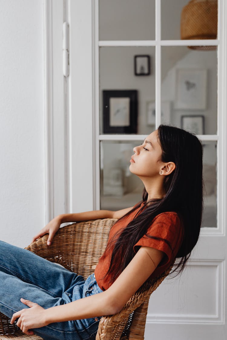 A Woman Relaxing On A Rattan Chair