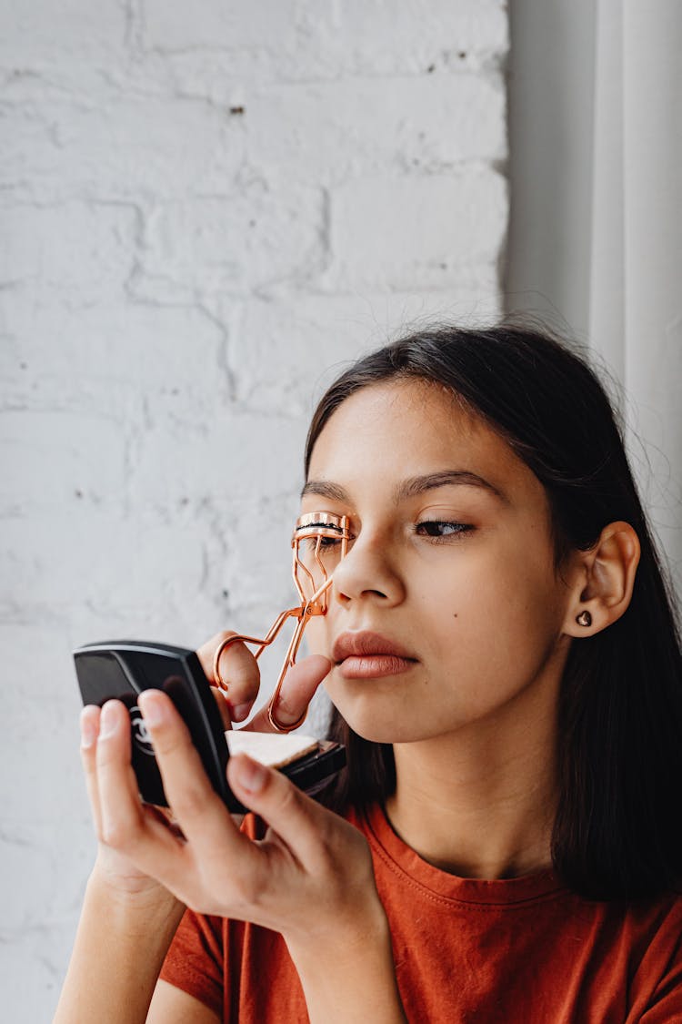 Girl Curling Lashes With Gold Eyelash Curler