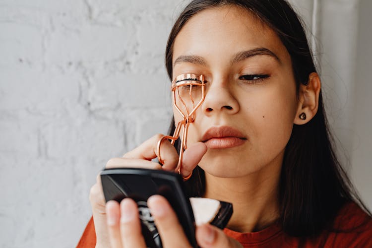 Girl Curling Lashes With Gold Eyelash Curler