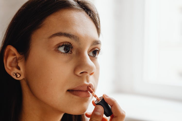 Close Up Photo Of Woman Applying Lipstick