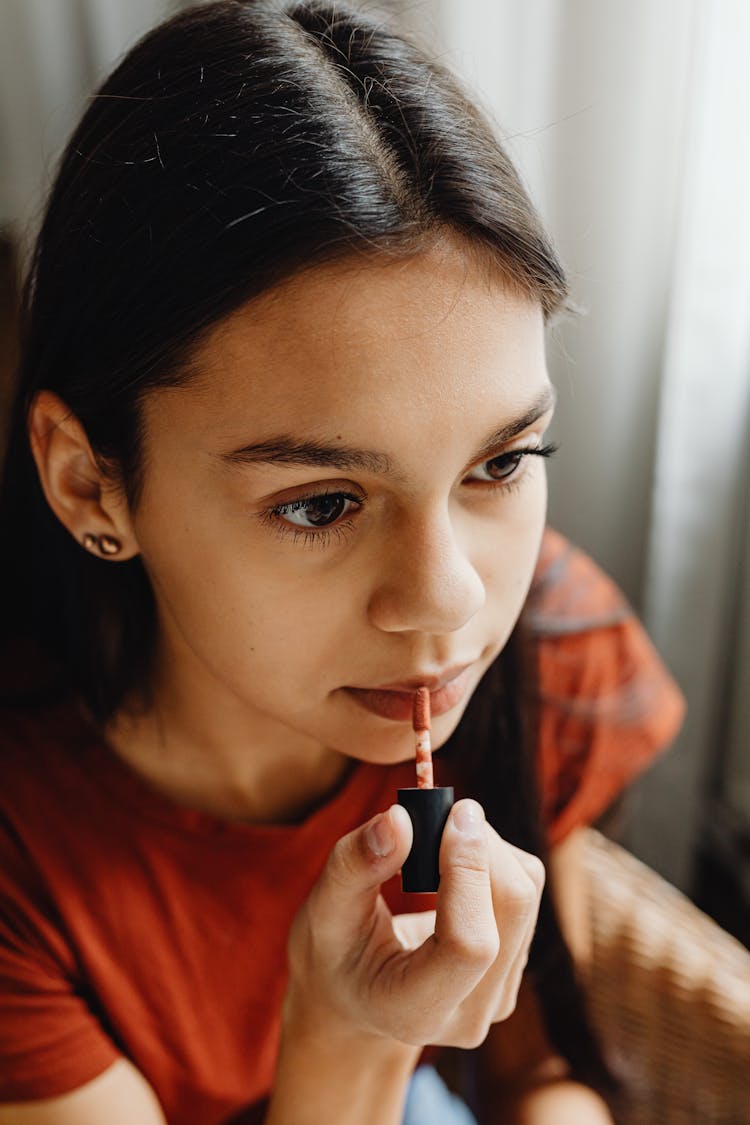 Close-Up Shot Of Pretty Woman Applying A Lip Tint