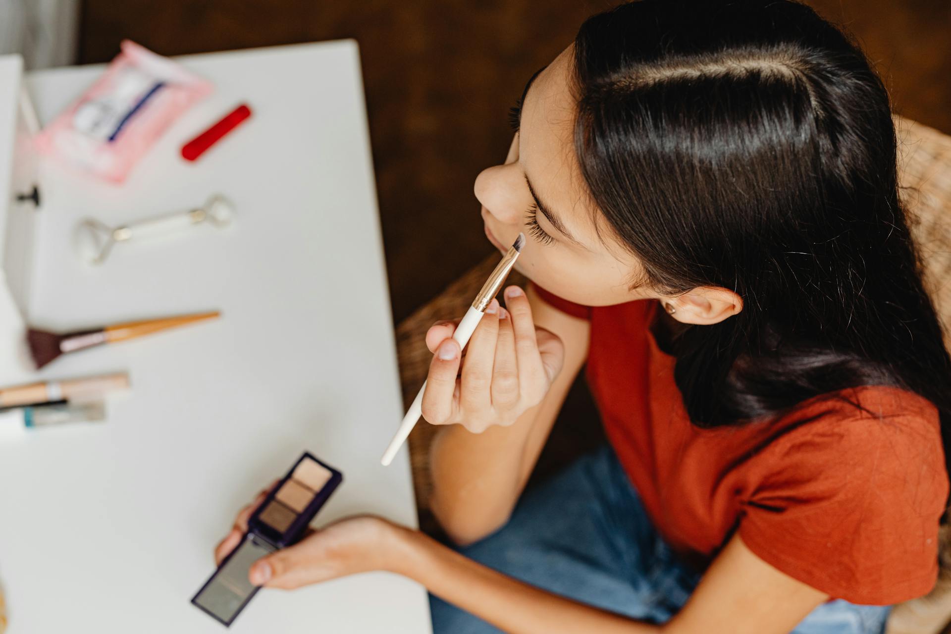 Close-Up Shot of a Teenage Girl Putting on Eyeshadow Makeup