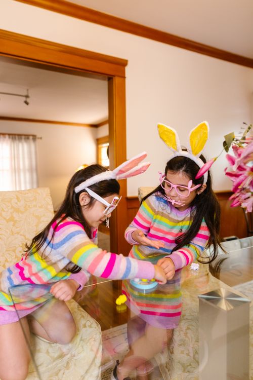 Free Two young girls in bunny costumes playing indoors, enjoying Easter activities. Stock Photo