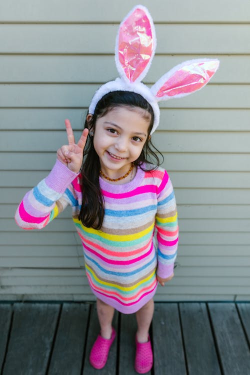 Girl Wearing Bunny Ears Doing Peace Sign 