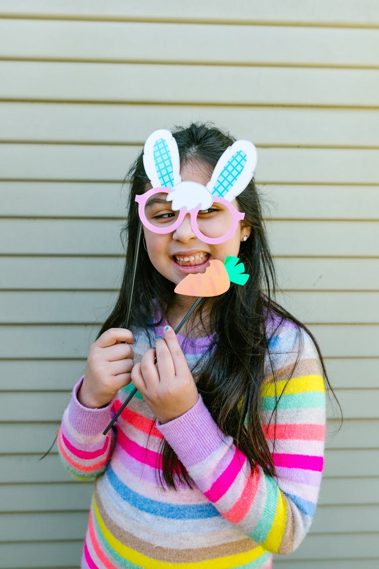 Girl In Colorful Sweatshirt Holding A Bunny Eyes And Carrot