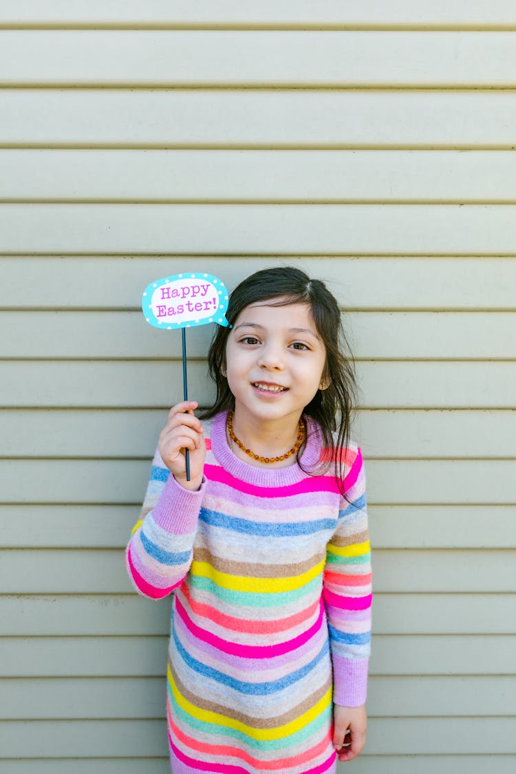 Girl Holding A Stick With Printed Happy Easter 