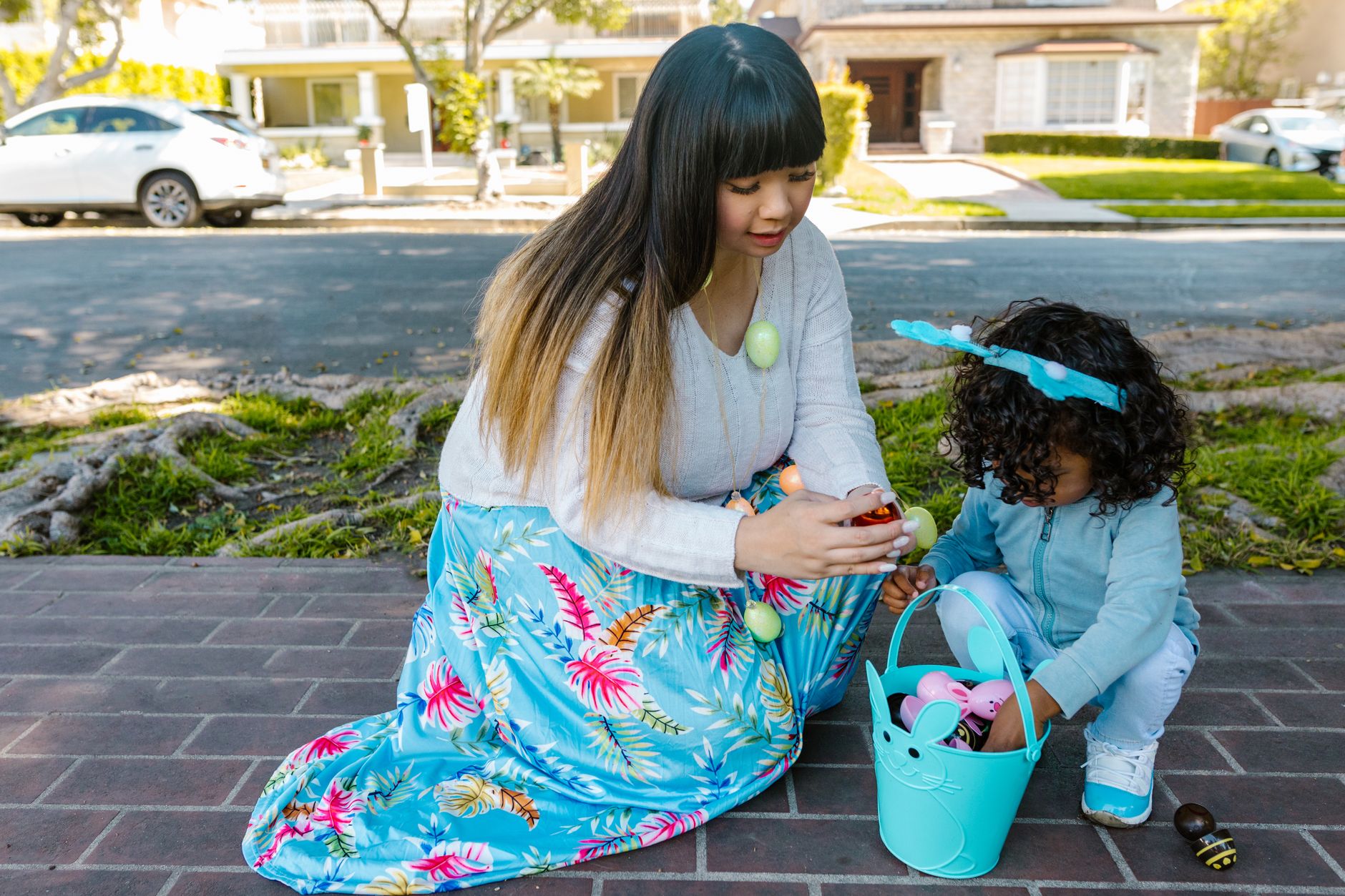 A mother and child enjoying an Easter egg hunt outdoors, bonding over holiday traditions.