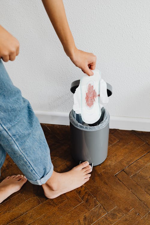 Person Throwing a Tampon in a Trash Bin