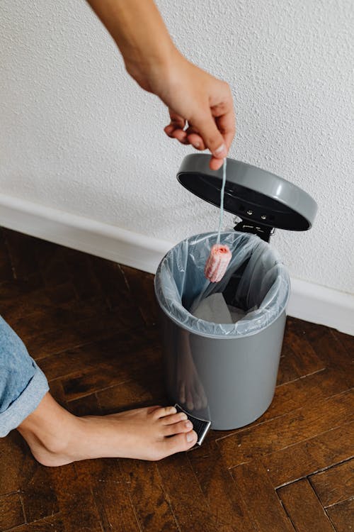 Person Throwing a Tampon in a Trash Bin