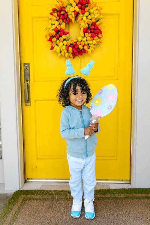 Little Girl Smiling while Standing at the Front Door