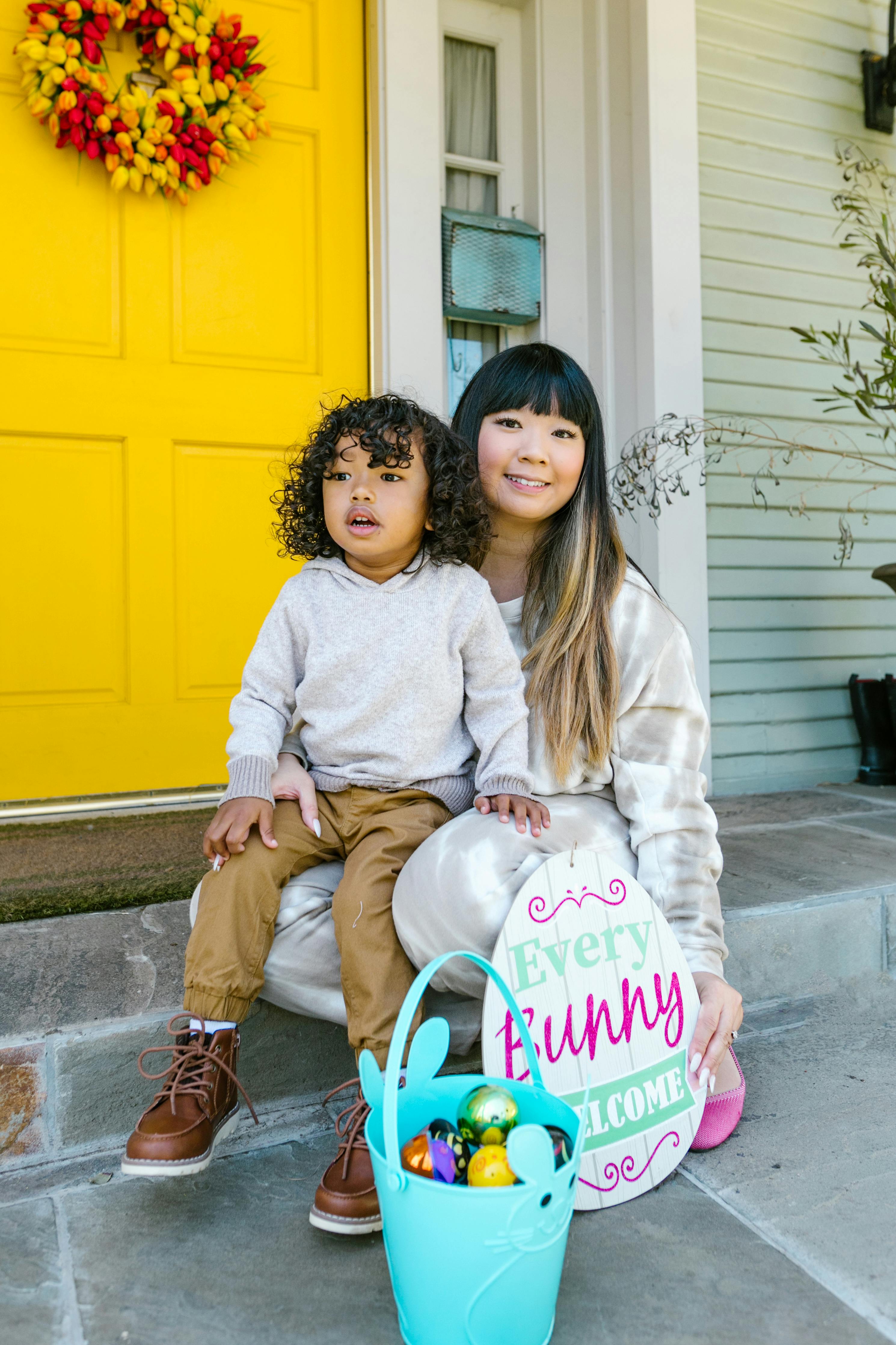 Mother and child sitting by a festive door, enjoying Easter together with decorations and joy.