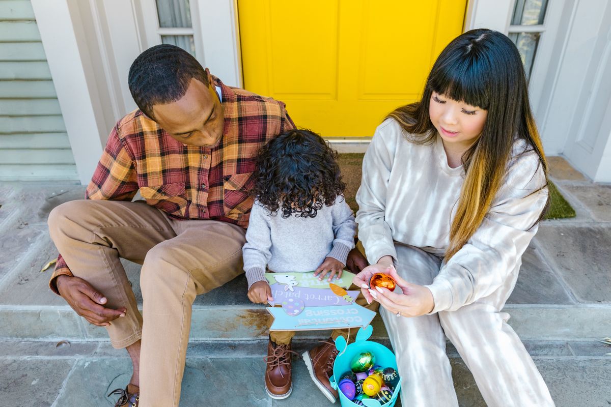 A multiracial family enjoying Easter activities on their front porch.