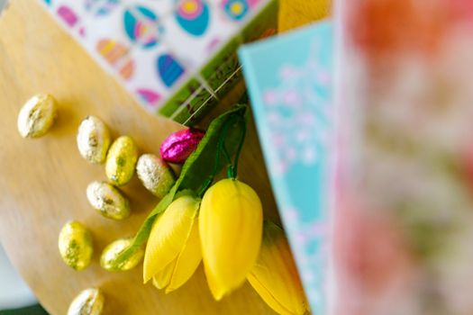 Vibrant Easter setup featuring golden wrapped chocolate eggs and spring floral decor for festive celebrations.