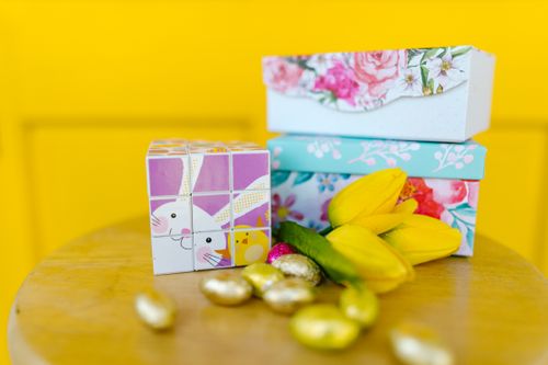 Free Colorful Easter setup with a cute bunny block, floral boxes, and yellow tulips. Stock Photo