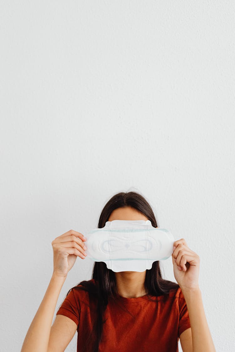 Woman Covering Face With Sanitary Pad