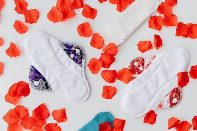 Close-Up Shot Of A Sanitary Napkins Near Red Petals