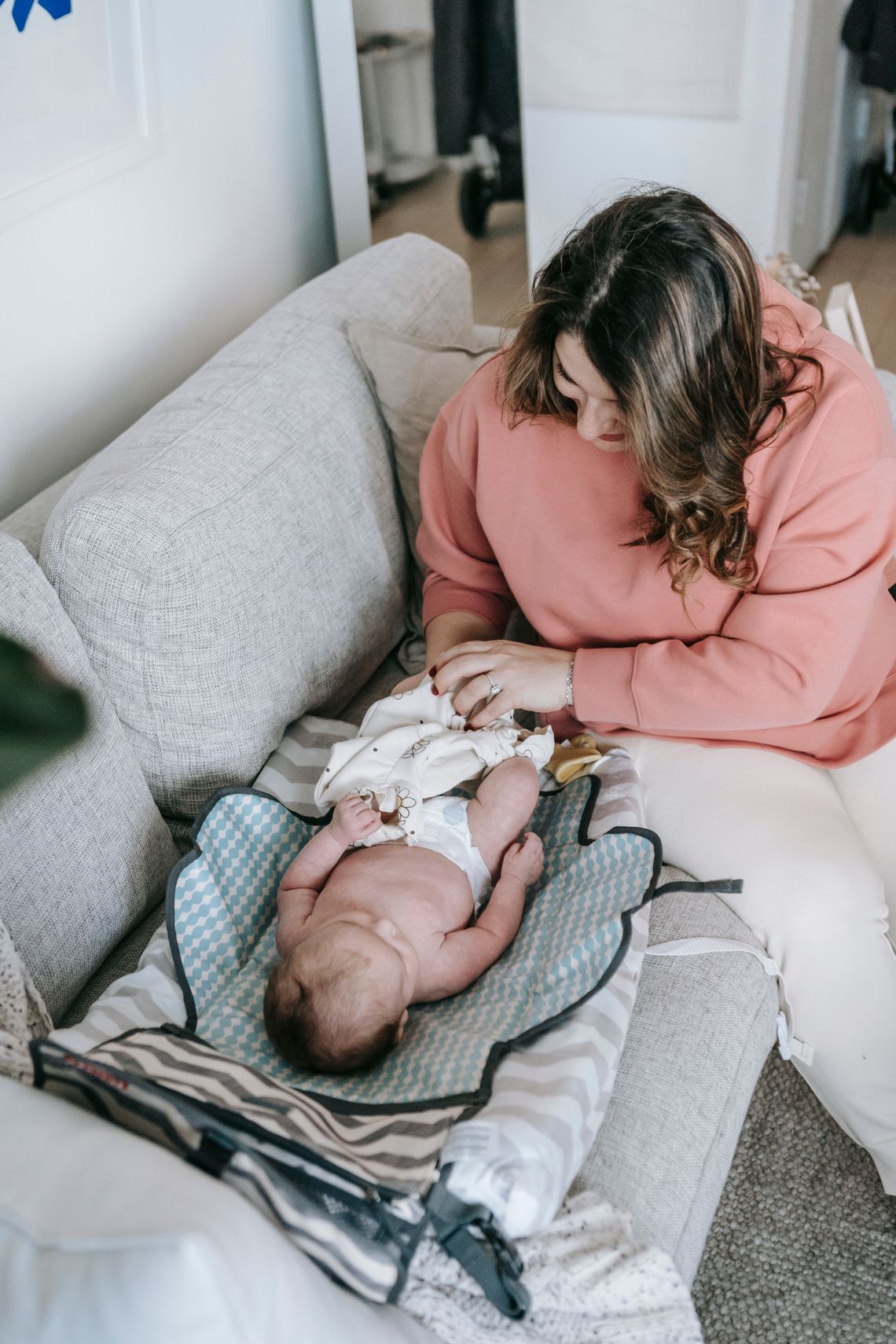 Mother gently dressing her baby during an everyday care routine