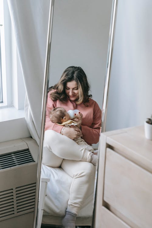 Free Reflection of a Woman and Baby on a Mirror Stock Photo