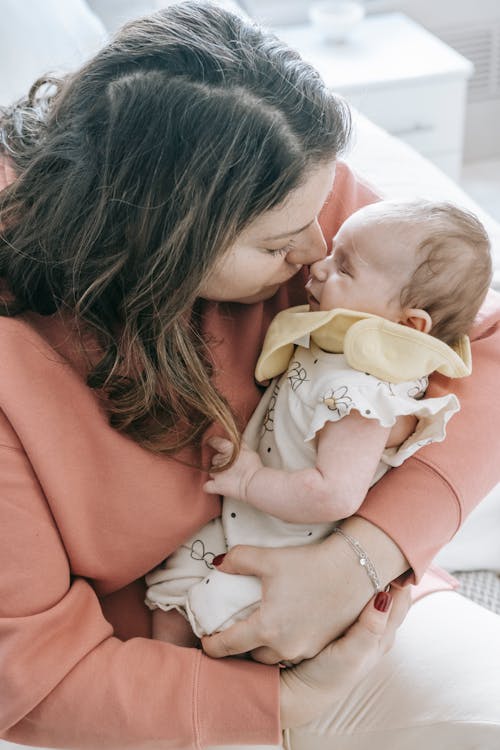 Free Mother kissing sleeping newborn baby Stock Photo