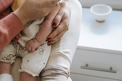 Crop mother with baby in hands