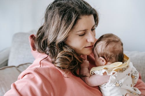 Mother with newborn baby on couch