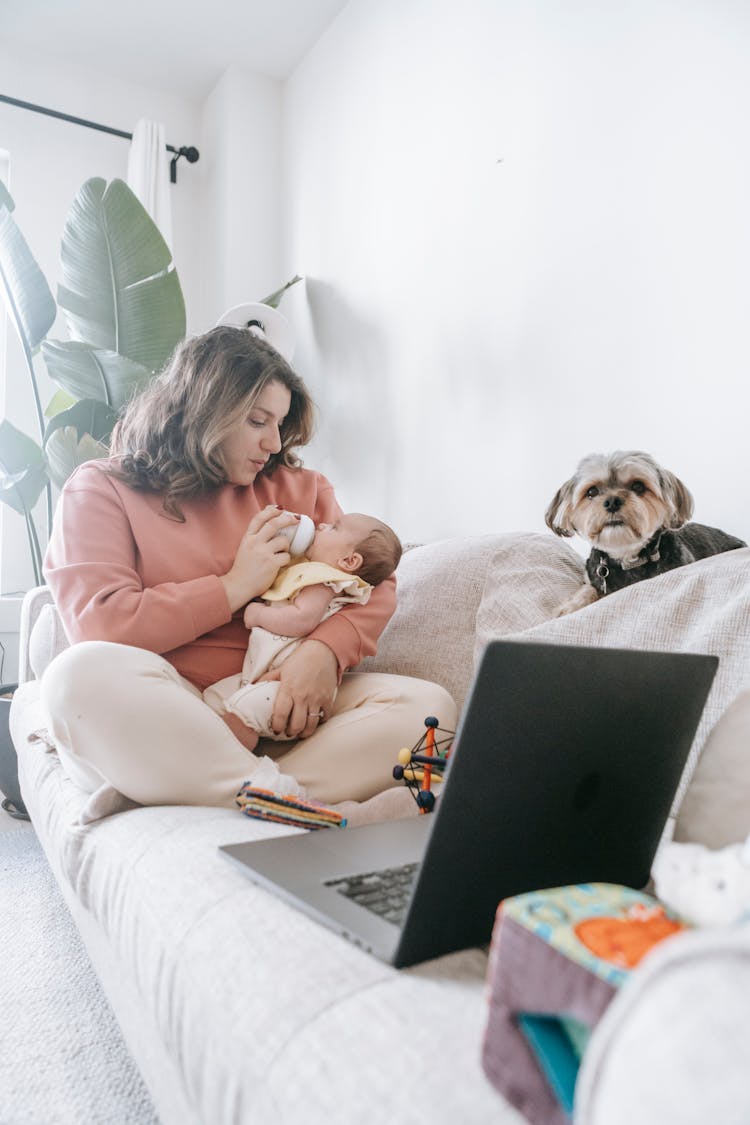 Mother Feeding Baby Near Dog