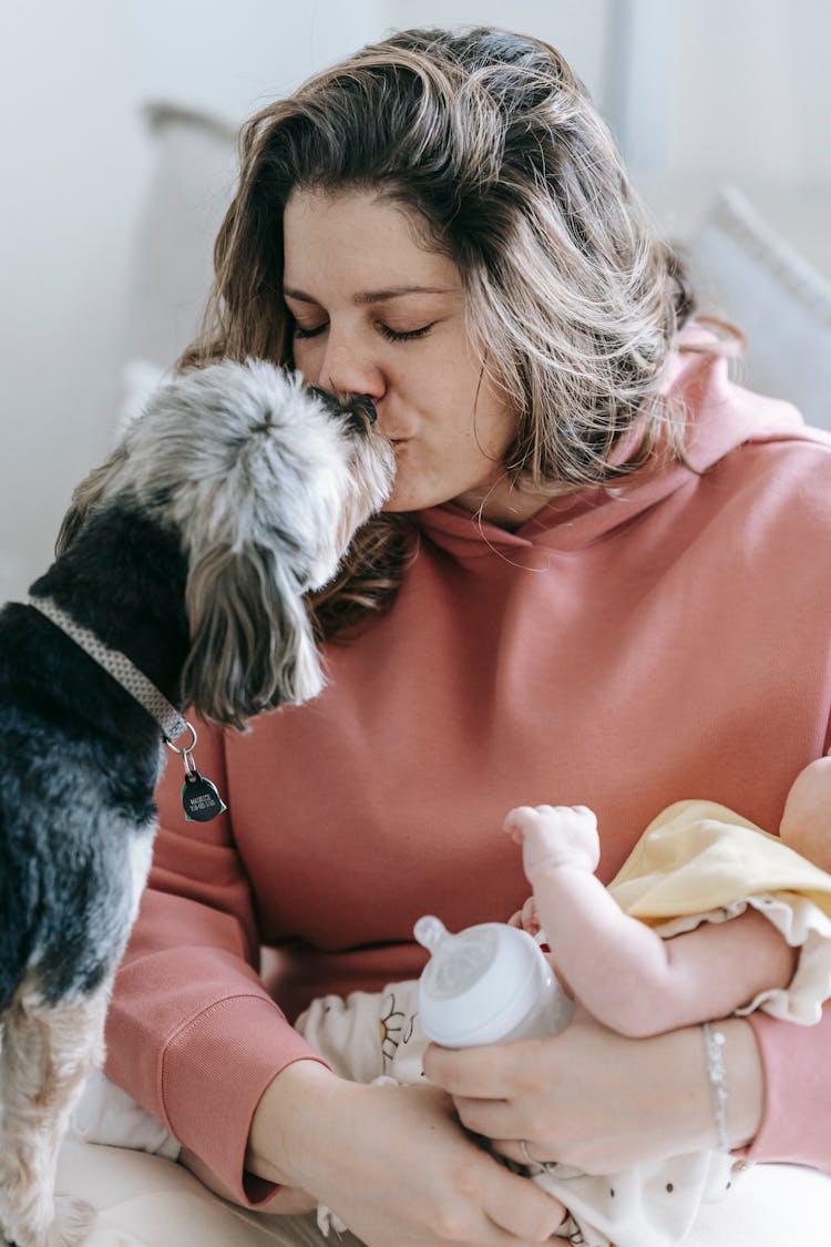 Woman With Faceless Baby Caressing Dog