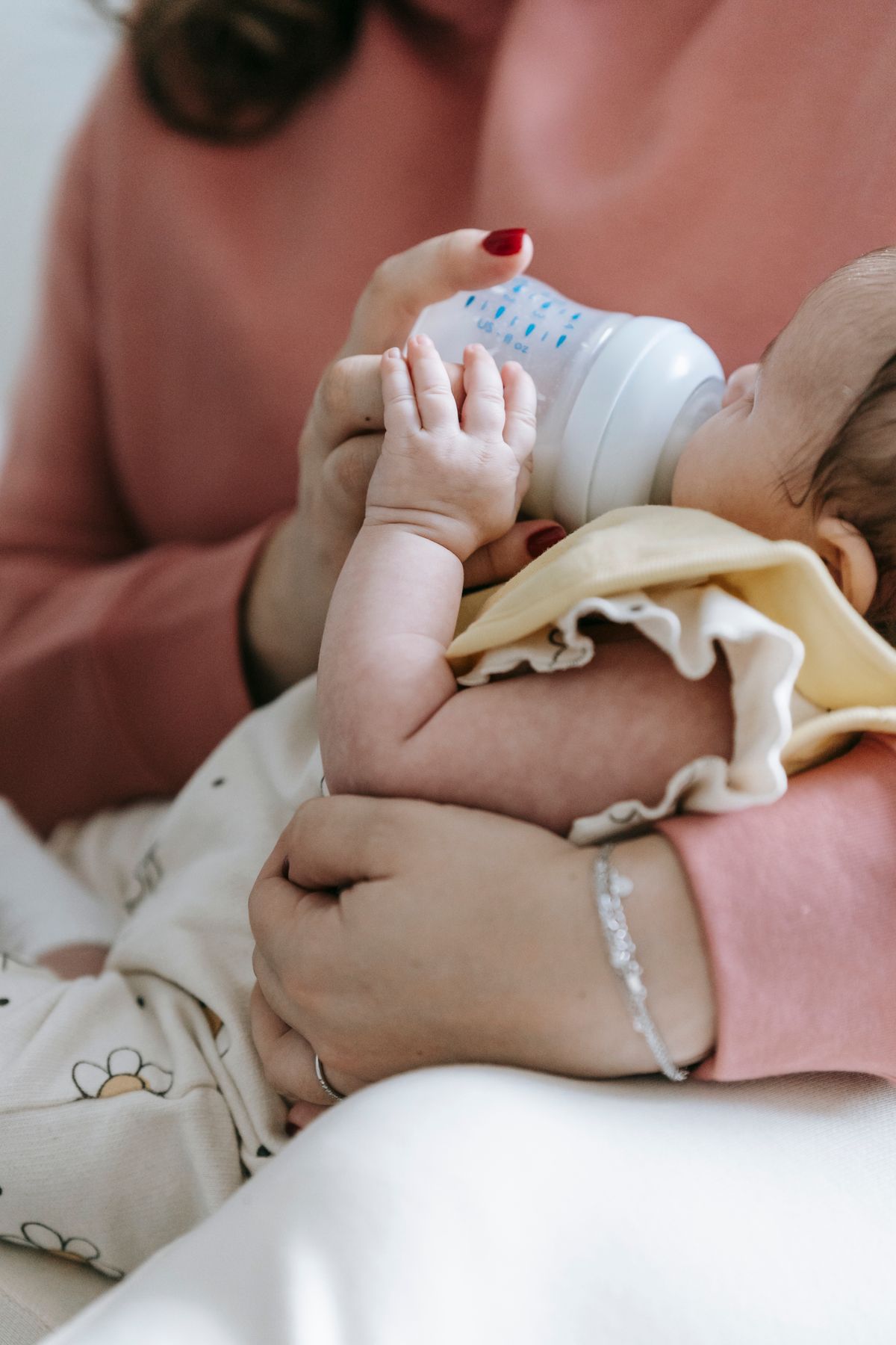 Mother gently bottle feeding her newborn baby