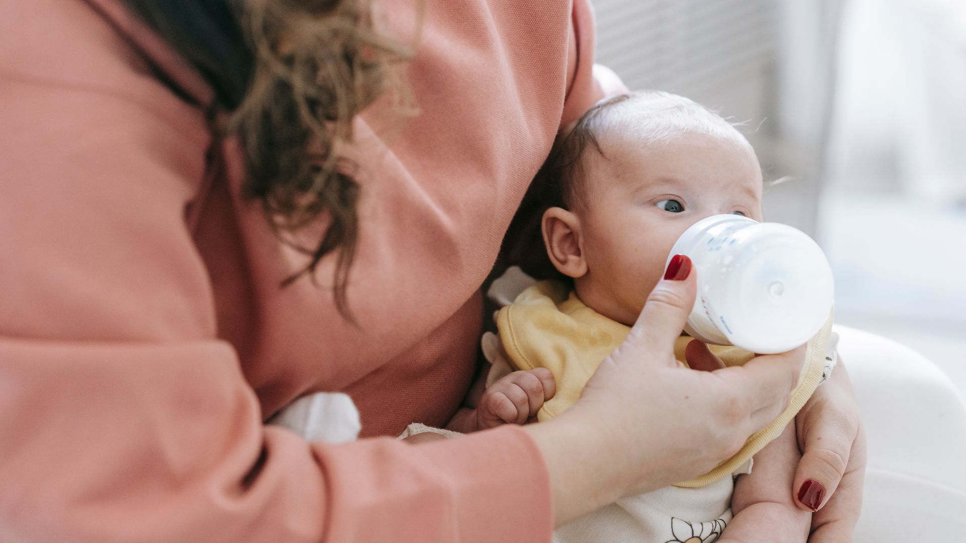 Modafinil Safety While Breastfeeding: A Comprehensive Guide Crop anonymous mother in casual clothes feeding adorable newborn baby with bottle while sitting on sofa in light room at home — modafinil safety while breastfeeding