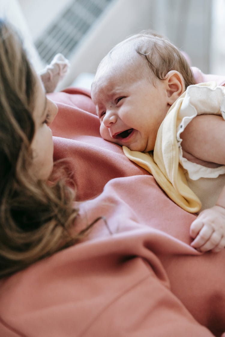 Crop Young Mother Hugging Adorable Crying Baby