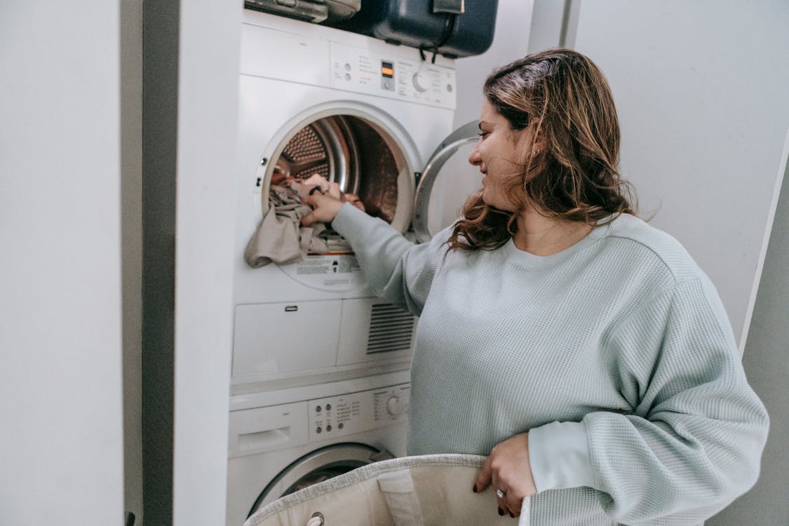 Woman Loading Washing Machine In Kitchen High-Res Stock Photo - Getty Images