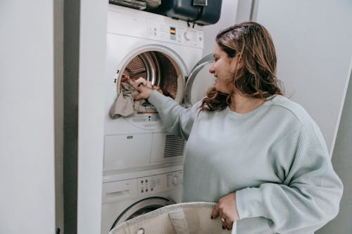 Free Positive woman loading washing machine Stock Photo