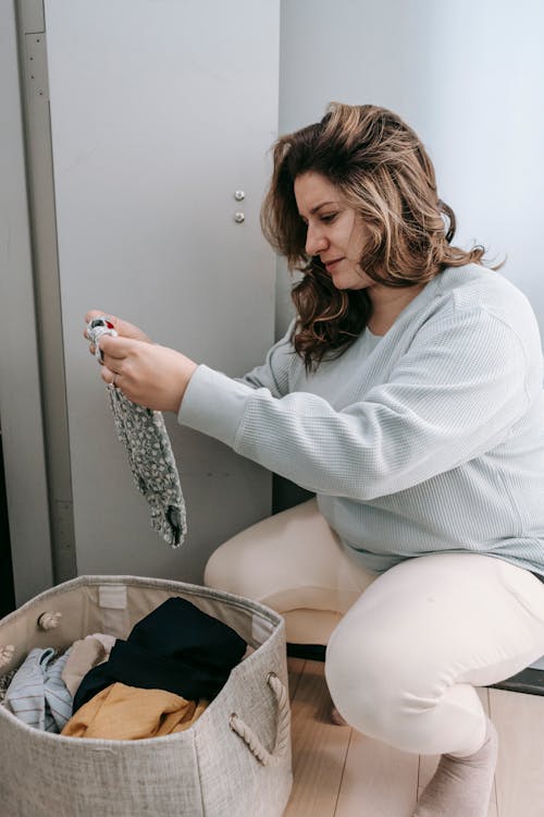 Free Woman choosing dirty clothes from basket Stock Photo