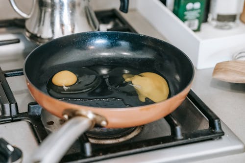 Free Eggs frying in pan on stove Stock Photo