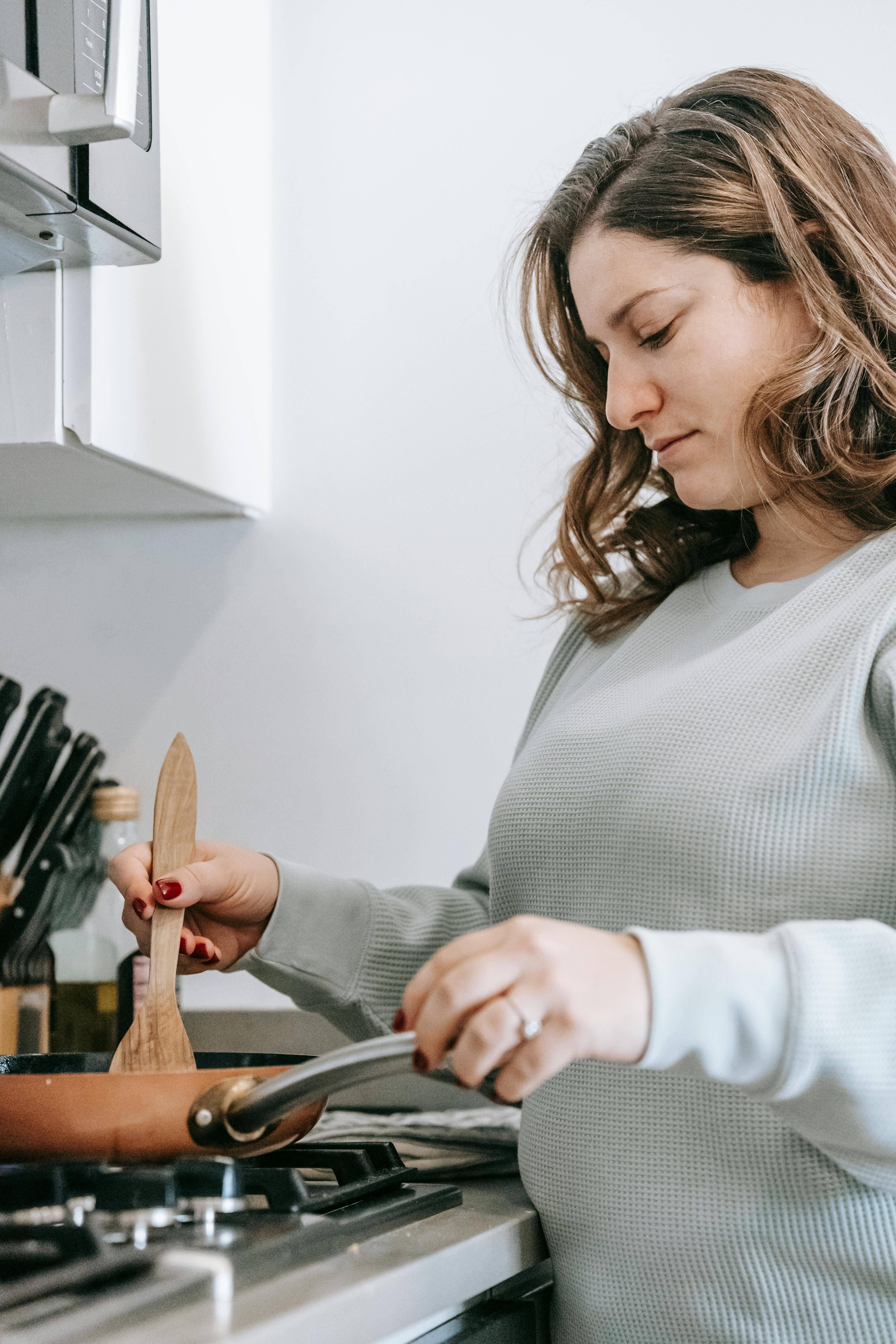 focused woman cooking on stove in kitchen